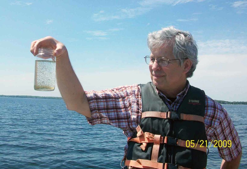 Stanley Dodson holding up a jar of Daphnia from Lake Mendota.